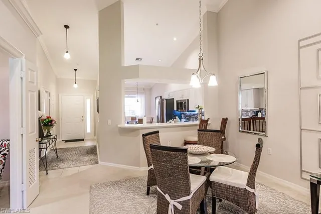 a dining room with stainless steel appliances kitchen island granite countertop a dining table chairs and view living room