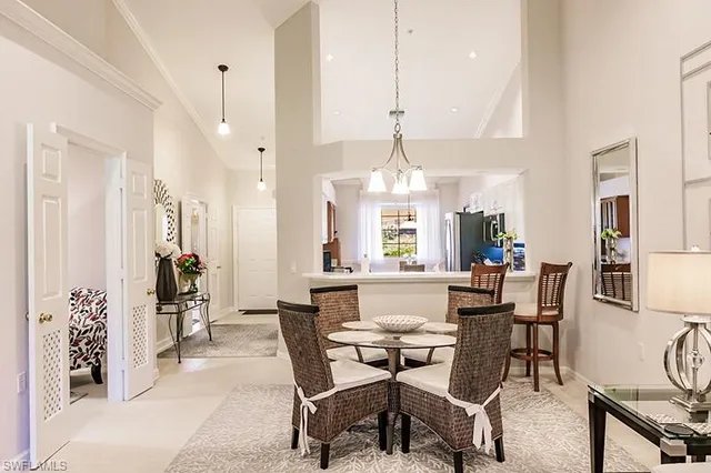 a view of a dining room and livingroom with furniture wooden floor a chandelier