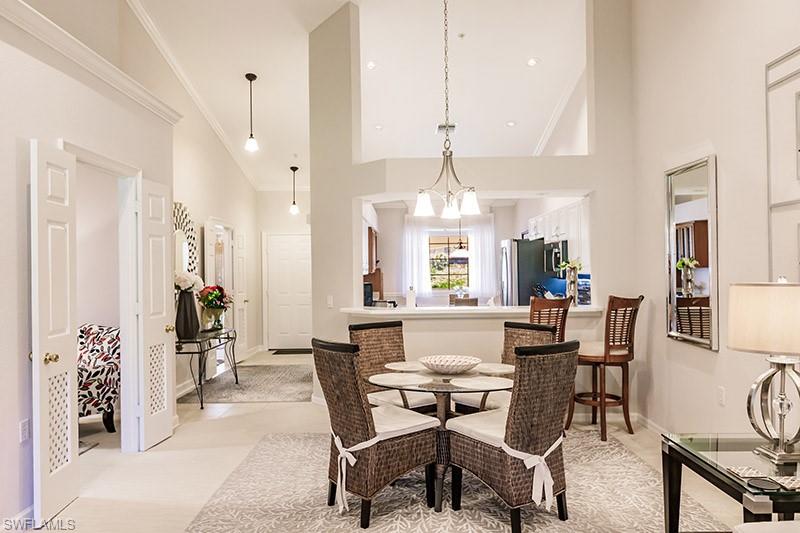 8135 Celeste Drive, Unit 4218 Naples, FL 34113 - Photo 9 of 37 a view of a dining room and livingroom with furniture wooden floor a chandelier