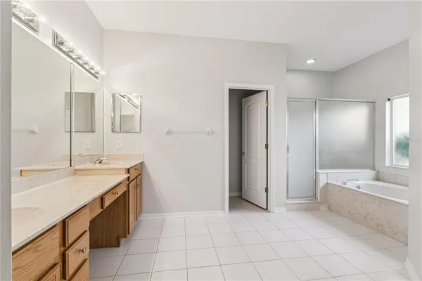 a spacious bathroom with a bathtub sink and mirror