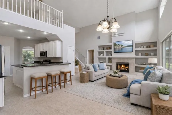 a living room with furniture a fireplace and a chandelier