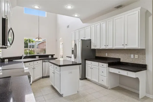 a kitchen with granite countertop white cabinets white stainless steel appliances with a sink and dishwasher