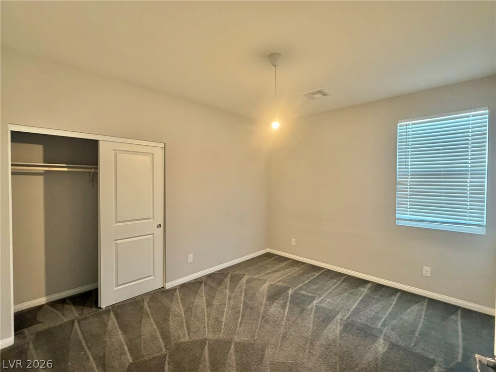 9953 Tucket Point Court Las Vegas, NV 89178 - Photo 22 of 22 A well-lit bedroom offering a closet with sliding doors and a window.