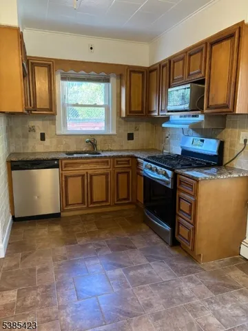 a kitchen with stainless steel appliances granite countertop a stove sink and cabinets