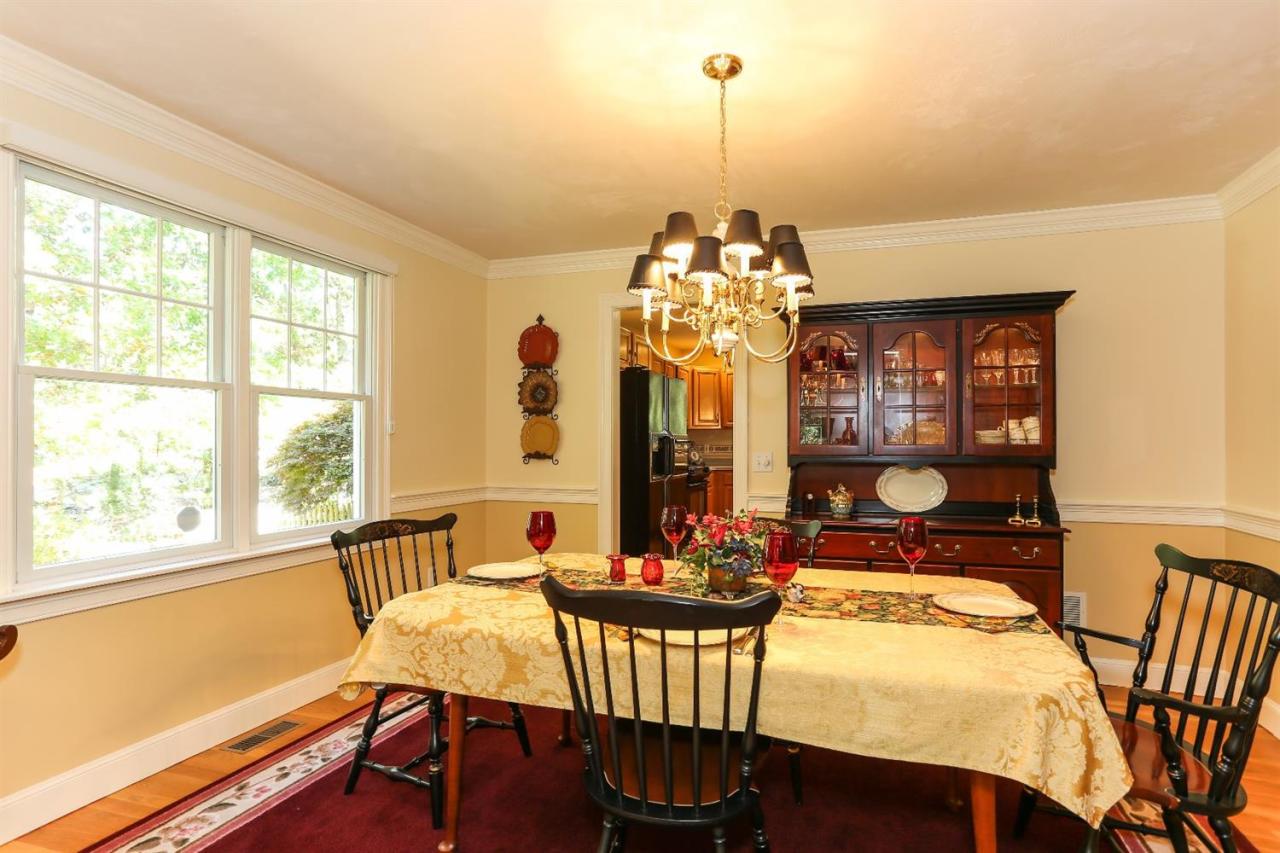 218 Little River Road Cotuit, MA 02635 - Photo 10 of 30 a view of a dining room with furniture a chandelier and large windows