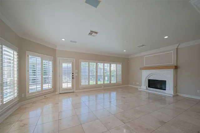 a view of an empty room with a fireplace and a window
