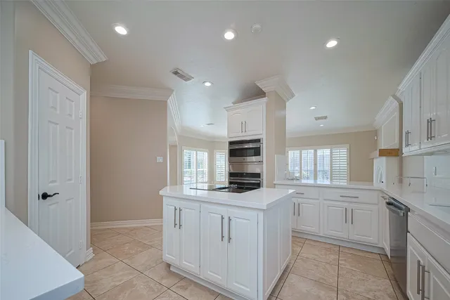 a kitchen with white cabinets and appliances