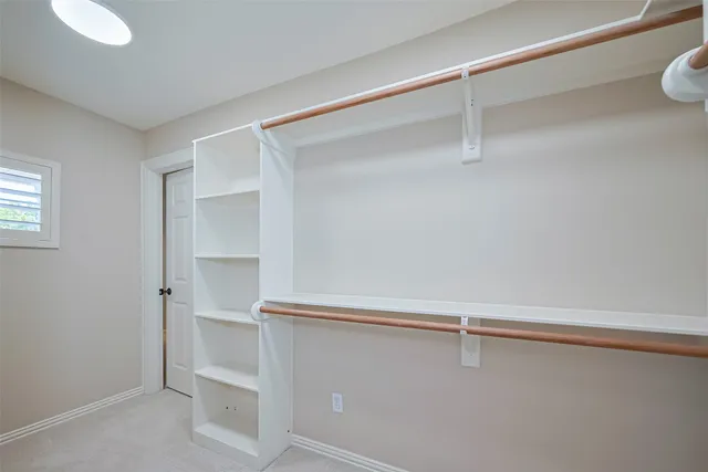 an empty room with windows and chandelier fan