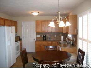 1412 Rough Rider Lane Parkton, NC 28371 - Photo 2 of 12 a kitchen with a chandelier a refrigerator and windows