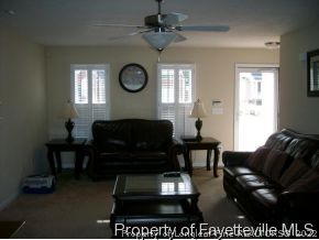1412 Rough Rider Lane Parkton, NC 28371 - Photo 3 of 12 a living room with furniture a clock and a window