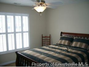 1412 Rough Rider Lane Parkton, NC 28371 - Photo 6 of 12 a bedroom with a bed and a chandelier