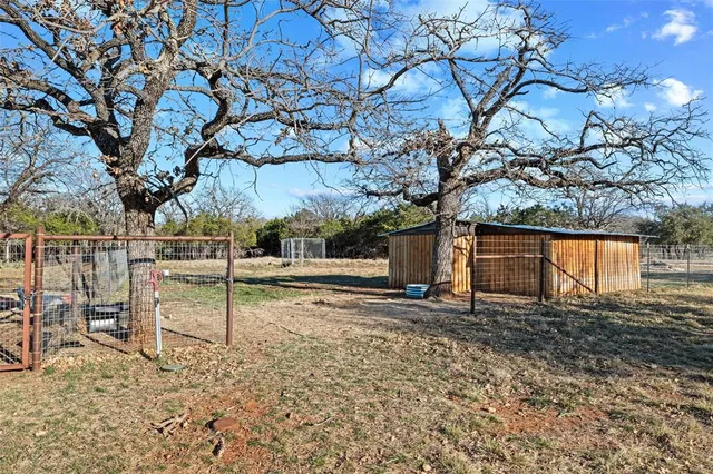 a backyard of a house with barbeque oven and seating space