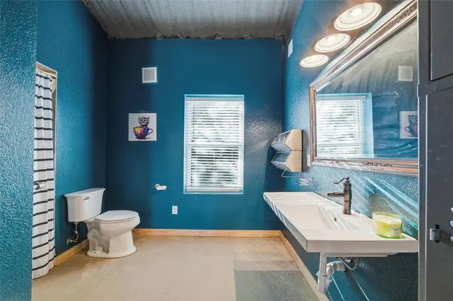 a bathroom with a toilet a sink and a mirror