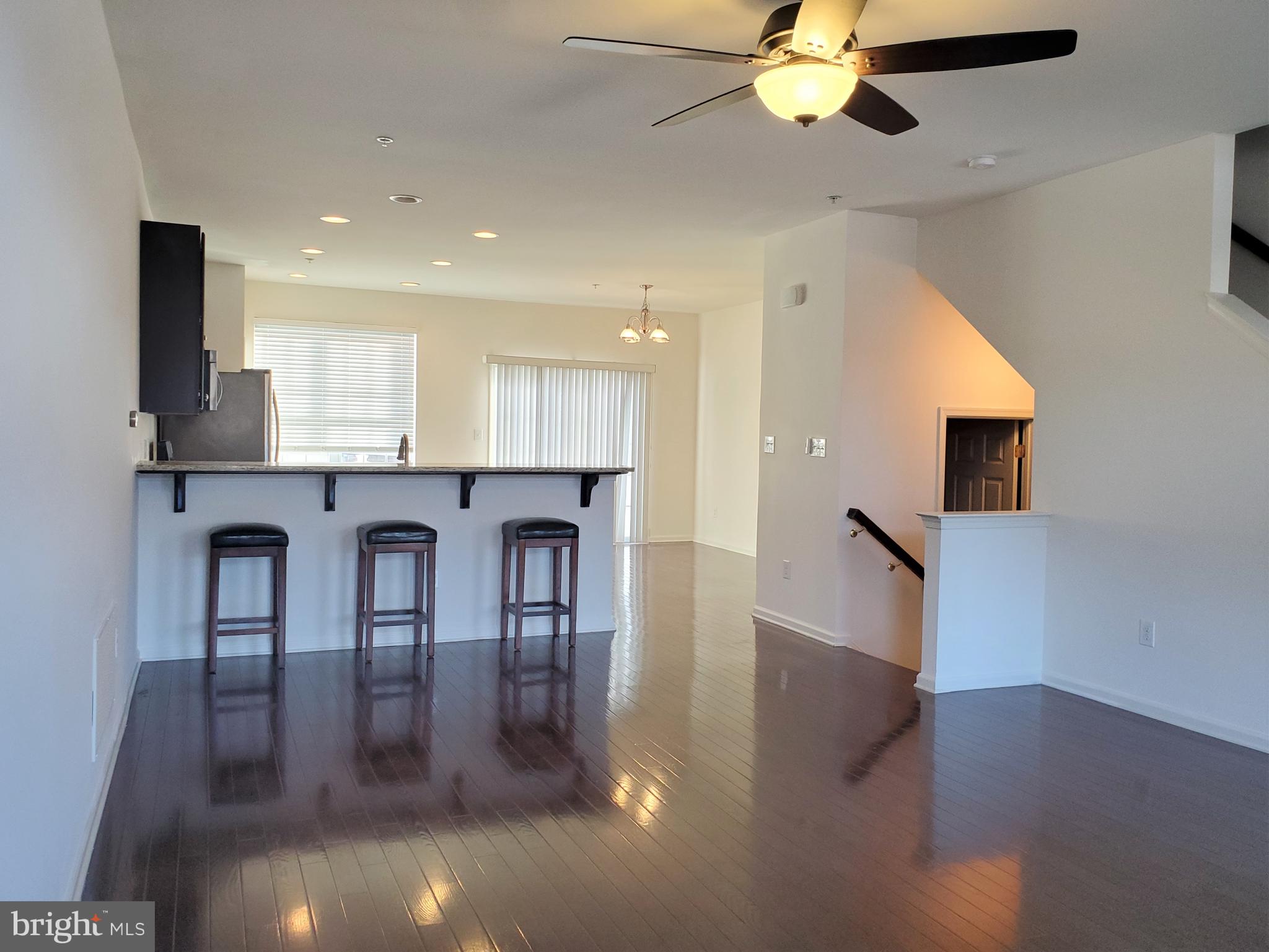 327 Lenape Way Claymont, DE 19703 - Photo 4 of 17 a kitchen with stainless steel appliances granite countertop a stove top oven a sink a dining table and chairs with wooden floor