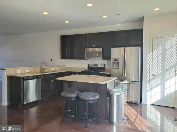 a kitchen with granite countertop a sink stainless steel appliances and cabinets