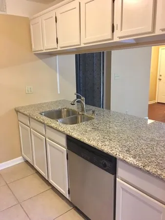 a kitchen with granite countertop a sink and cabinets