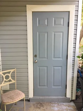 a view of a door and a chair in the balcony