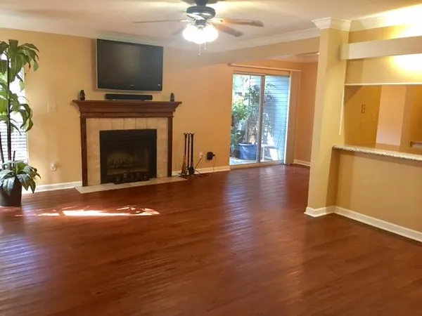 a view of a livingroom with furniture a fireplace wooden floor and a flat screen tv