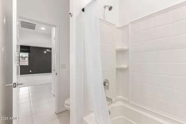 an empty room with windows and ceiling fan