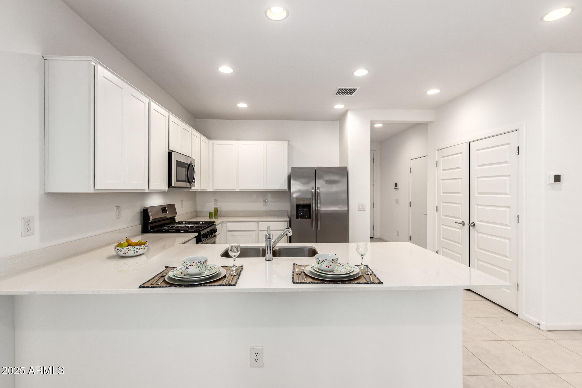 12524 West Trumbull Road Avondale, AZ 85323 - Photo 3 of 34 a kitchen with stainless steel appliances kitchen island granite countertop a sink refrigerator and cabinets