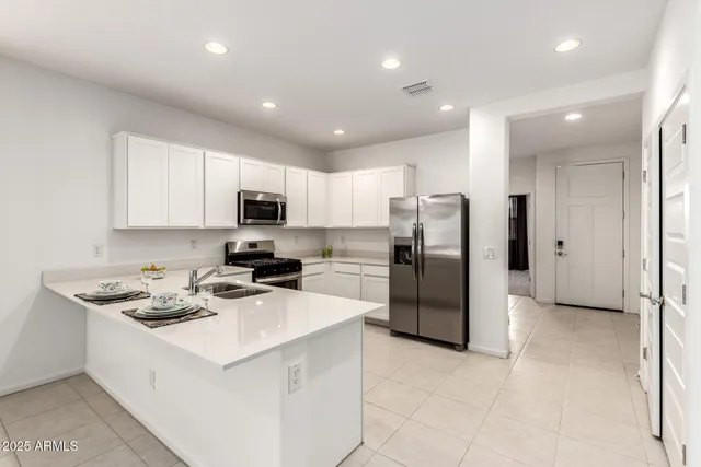 a kitchen with stainless steel appliances granite countertop a refrigerator stove microwave and sink