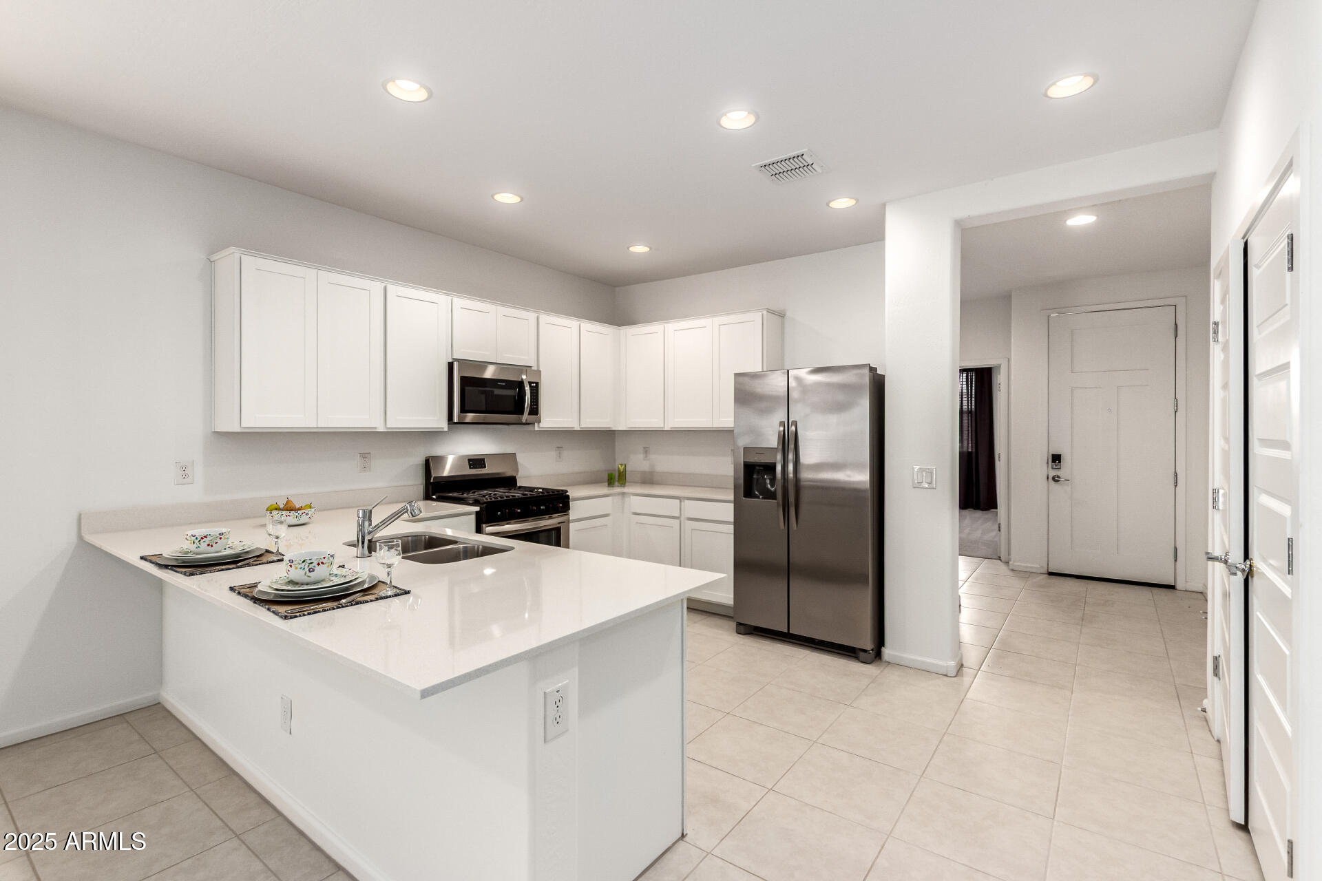 12524 West Trumbull Road Avondale, AZ 85323 - Photo 4 of 34 a kitchen with stainless steel appliances granite countertop a refrigerator stove microwave and sink