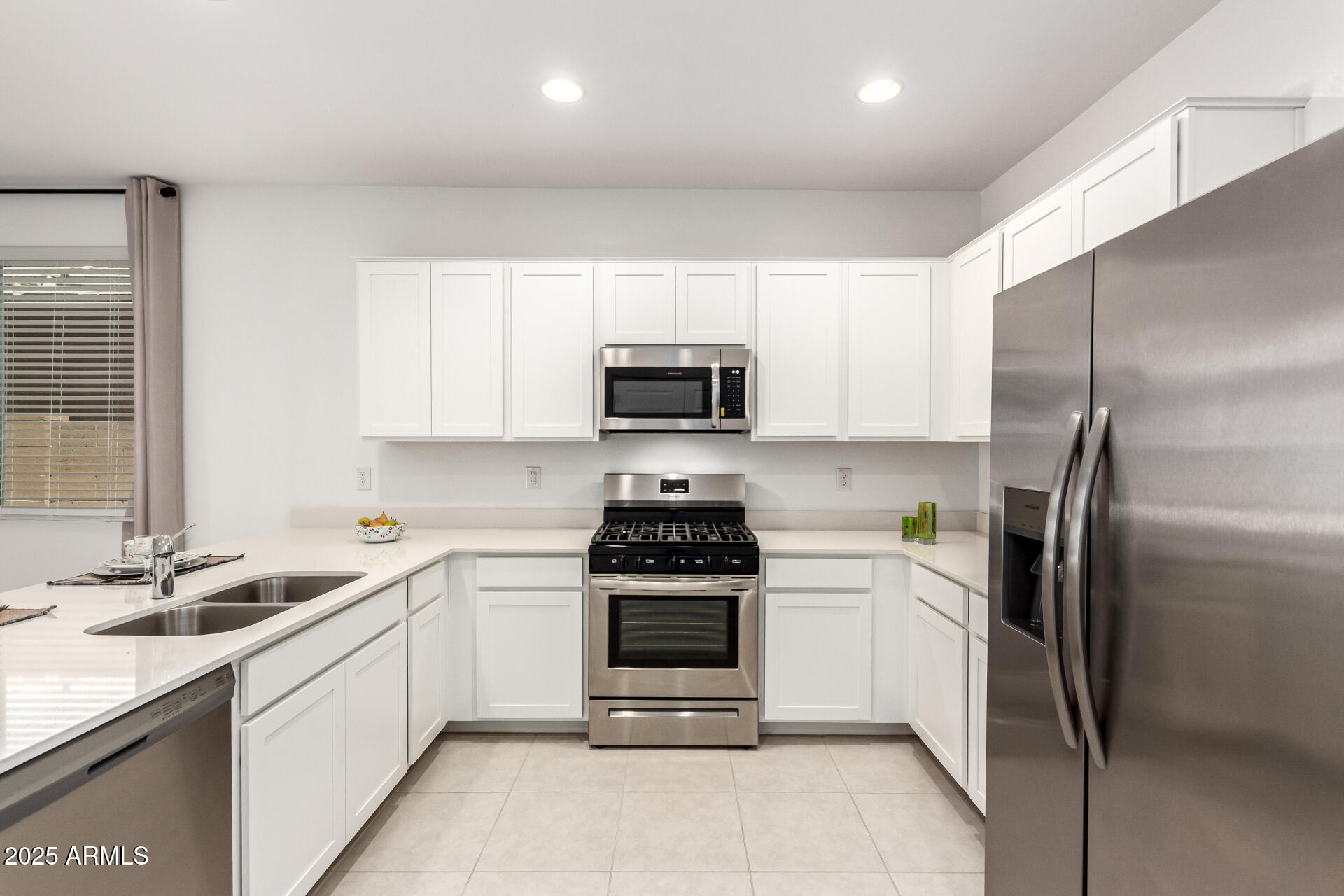 12524 West Trumbull Road Avondale, AZ 85323 - Photo 5 of 34 a kitchen with a sink a stove and refrigerator