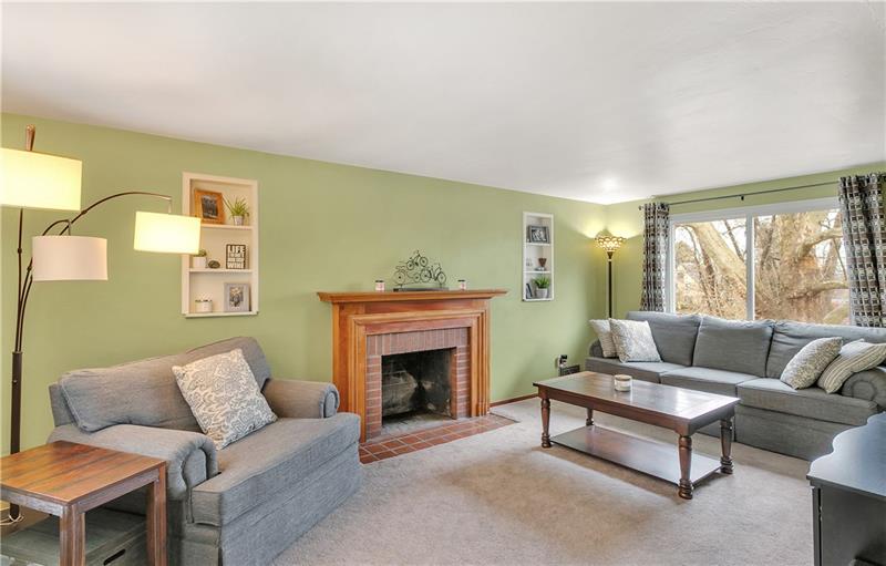 The Spacious Living Room, Measuring 19x11, has a Gorgeous Brick Fireplace with Beautiful Wood Mantle and Surround that is Flanked by Two Built in, Recessed Shelves.  