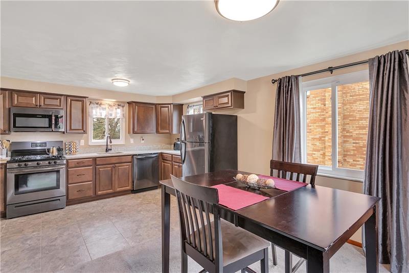Open Dining Room / Kitchen with Newer Tile Floor and Fresh, Neutral Paint Color.