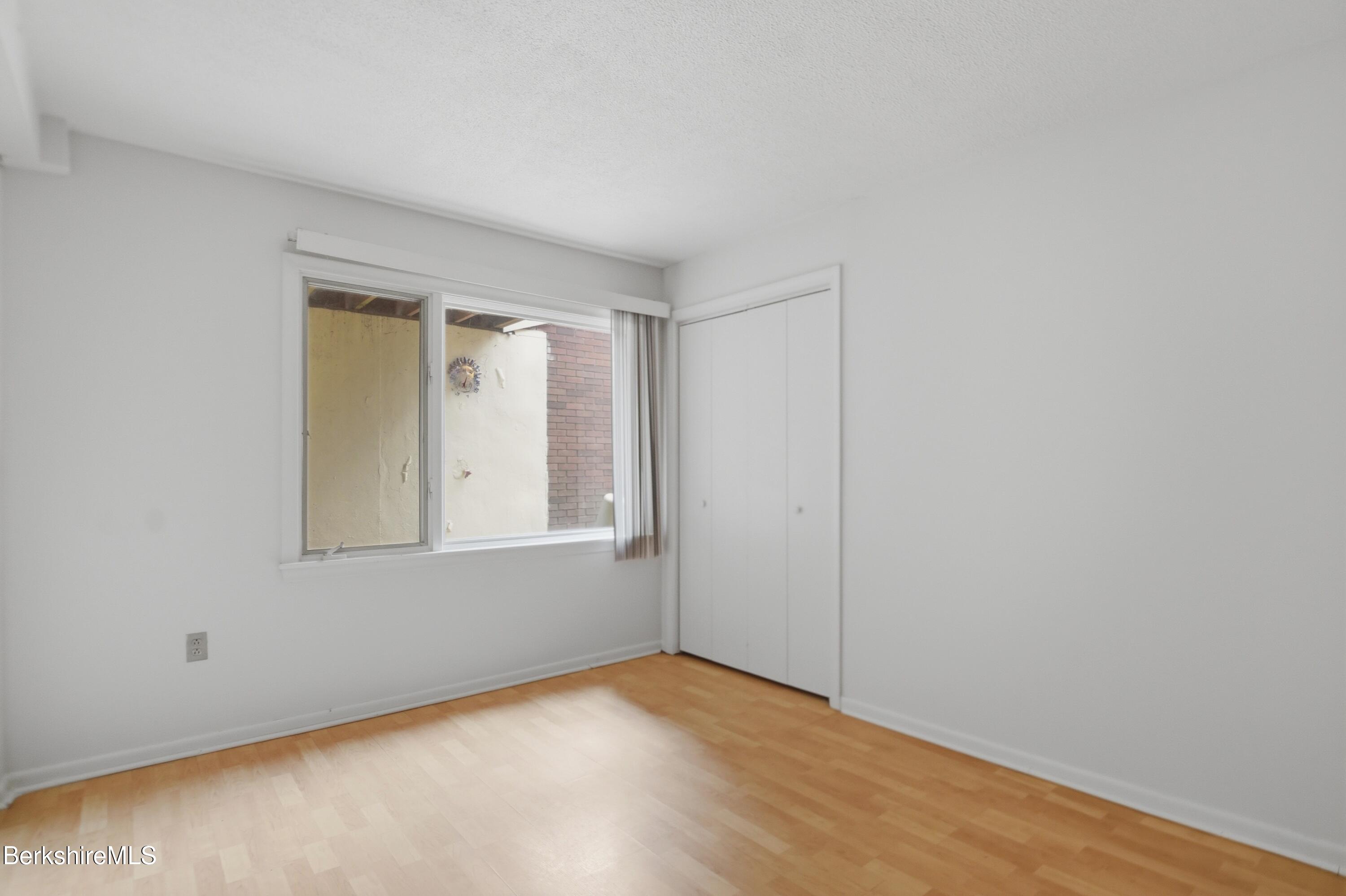 1 Colt Road, Unit 1 Pittsfield, MA 01201 - Photo 25 of 28 a view of an empty room with wooden floor and a window