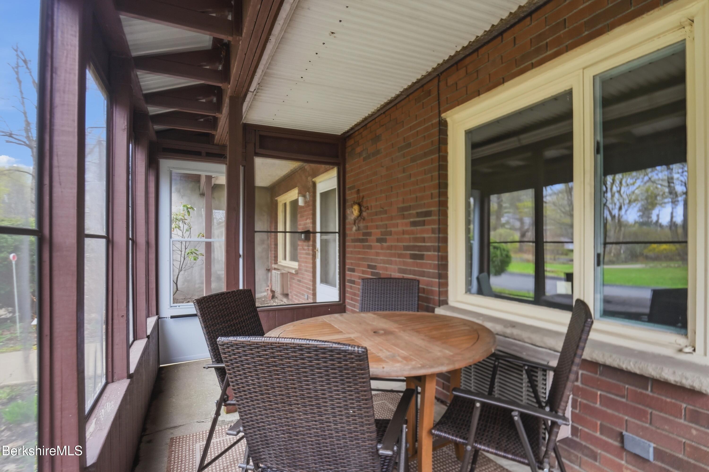 1 Colt Road, Unit 1 Pittsfield, MA 01201 - Photo 28 of 28 a view of a patio with table and chairs with wooden floor and floor to ceiling window