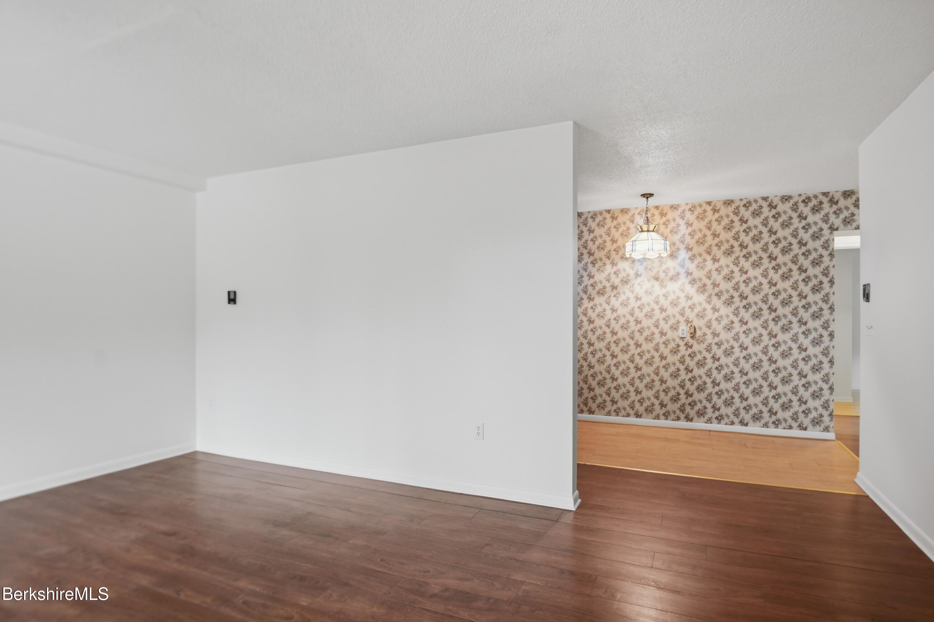 1 Colt Road, Unit 1 Pittsfield, MA 01201 - Photo 9 of 28 a view of an empty room with wooden floor and cabinet