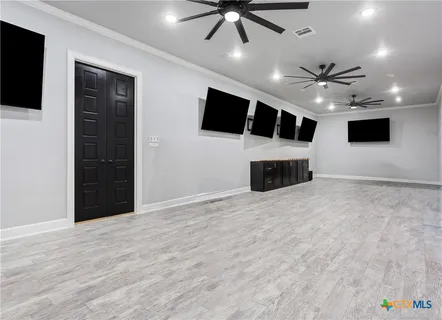 a big room with windows fireplace and a chandelier fan