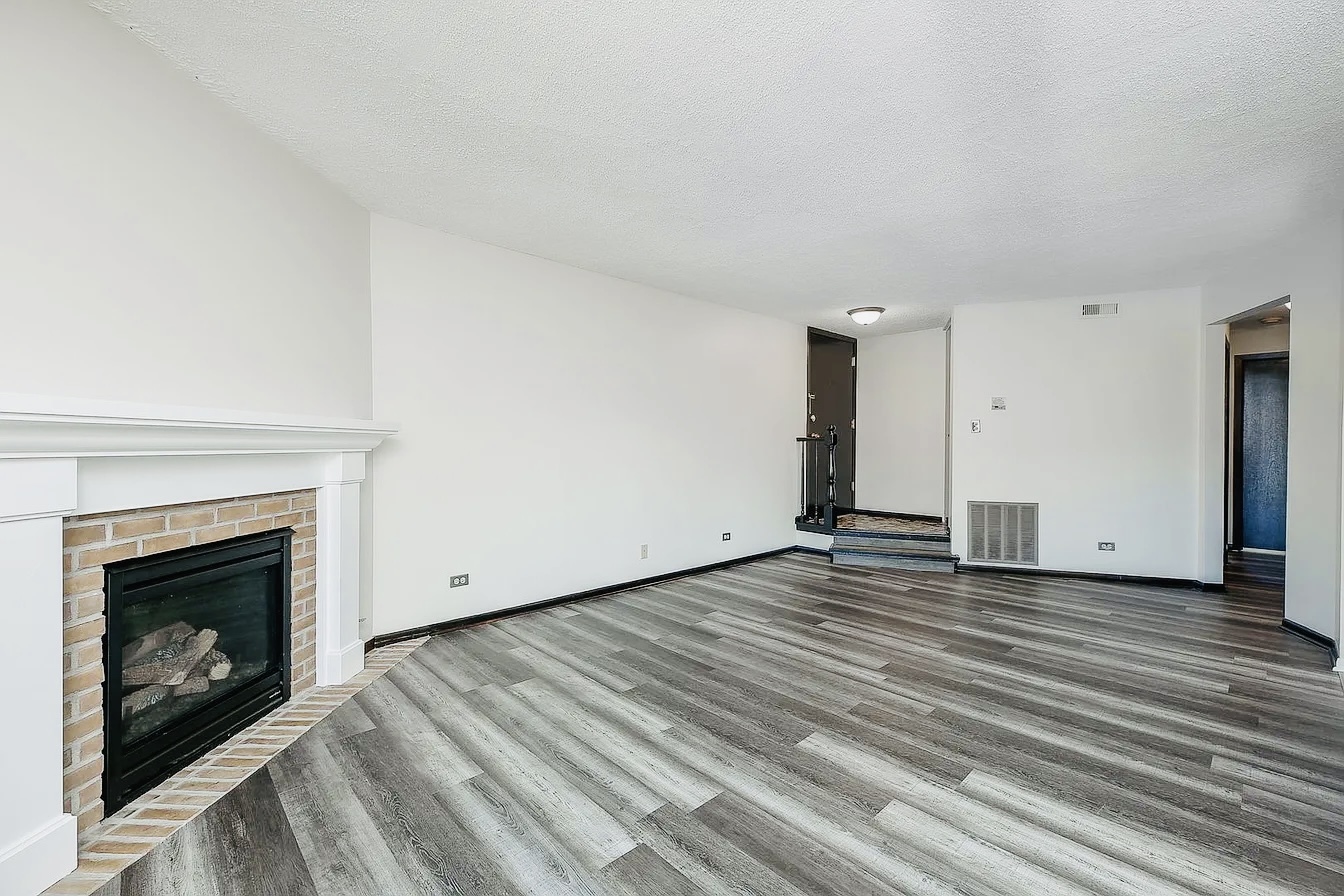 865 Sheldon Court, Unit C Wheaton, IL 60189 - Photo 2 of 11 a view of an empty room with wooden floor fireplace and a window