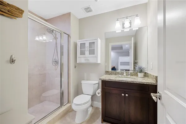 a bathroom with a granite countertop sink a toilet and a mirror