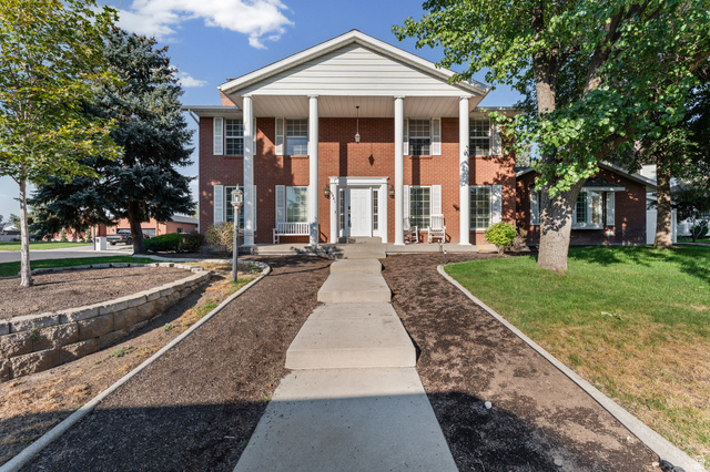 8441 Rua Branco Drive Sandy, UT 84093 - Photo 2 of 47 Classic brick Colonial with commanding front elevation featuring a white-columned portico, gabled roofline, and symmetrical facade