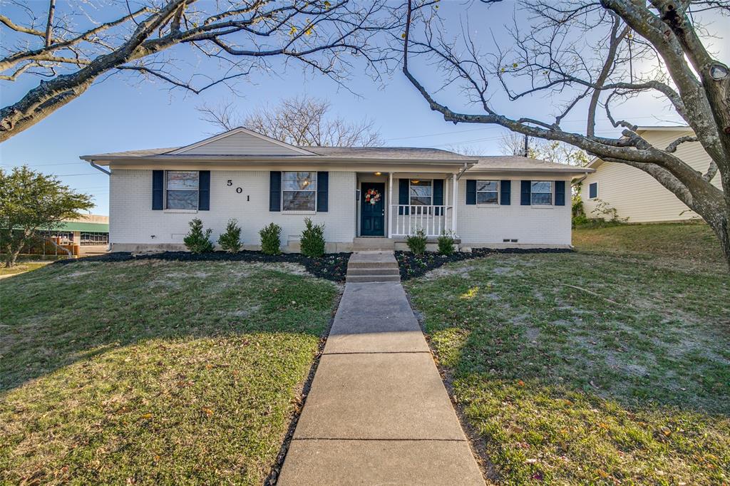 a front view of a house with a yard and potted plants