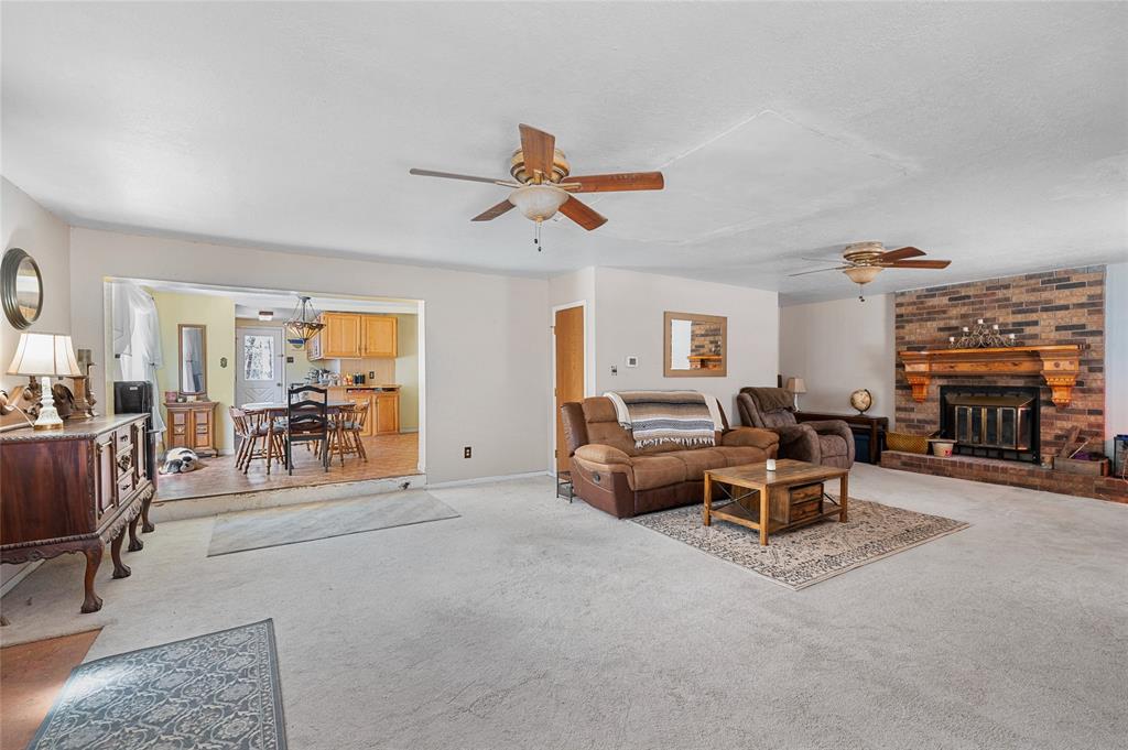 101 Frazier Oaks Road Pottsboro, TX 75076 - Photo 12 of 36 a living room with furniture a fireplace and a flat screen tv