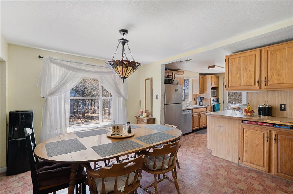 101 Frazier Oaks Road Pottsboro, TX 75076 - Photo 13 of 36 a kitchen with a dining table chairs and white cabinets