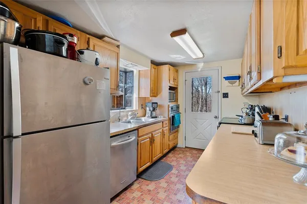 a kitchen with stainless steel appliances granite countertop a refrigerator a stove and a sink