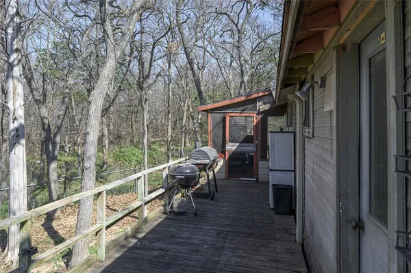a view of a backyard with large tree and wooden fence