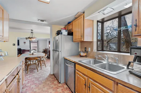 a kitchen that has a refrigerator a sink and a stove top oven
