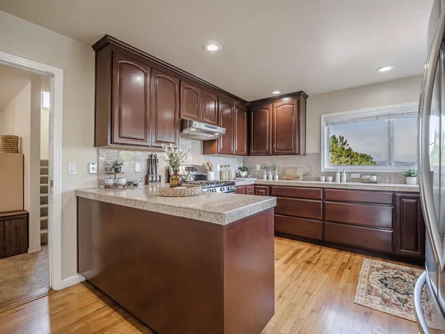 a kitchen with kitchen island granite countertop wooden cabinets a sink and dishwasher