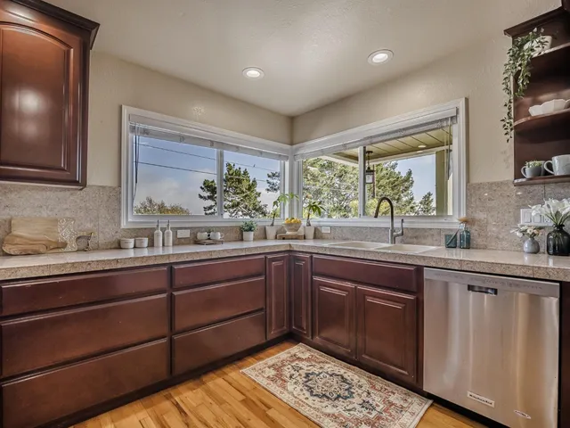 a kitchen with stainless steel appliances granite countertop wooden cabinets and a sink