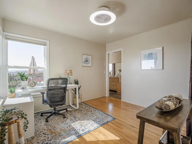 a view of a workspace with furniture and a window