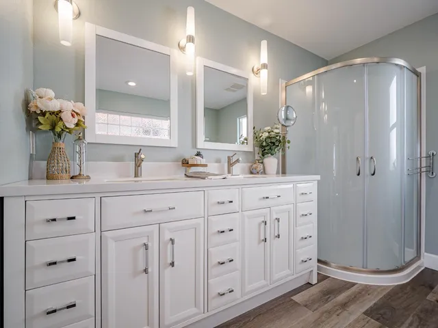 a bathroom with a double vanity sink mirror and shower