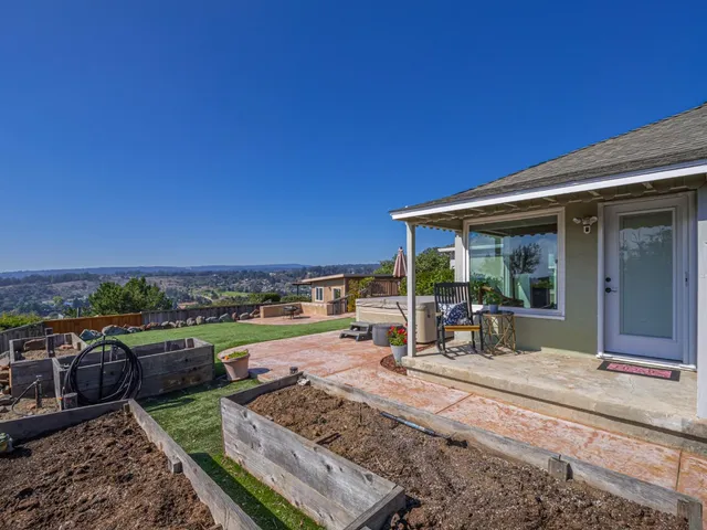 a view of a patio with chairs and table potted plants and palm tree