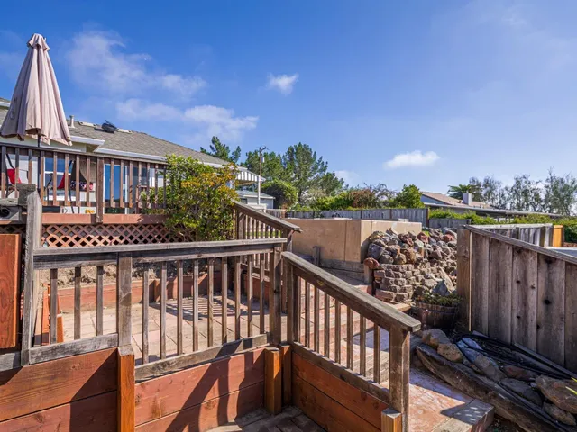 a view of a brick house with wooden fence