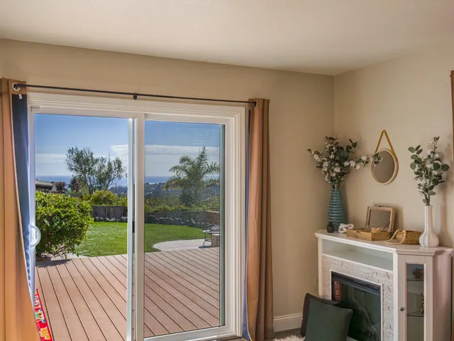 a view of a livingroom with a fireplace a potted plant and wooden floor