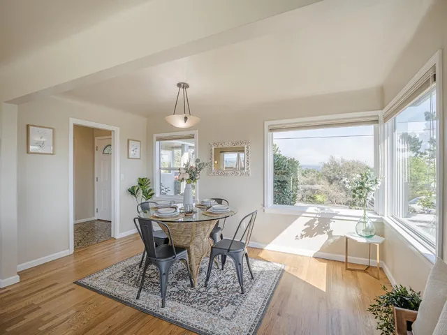 a dining room with wooden floor a chandelier a glass table and chairs